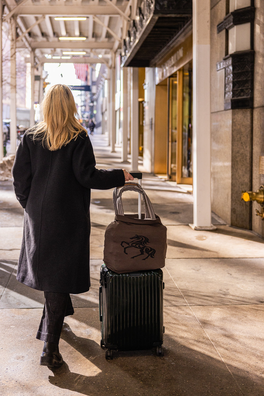 Person walking with a suitcase and a brown Rydir Band in an urban setting